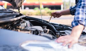 Una mano extrae la varilla del lubricante para comprobar el nivel de aceite
