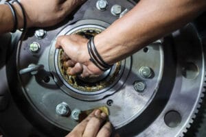 Un técnico aplica grasa a un rodamiento, uno de los puntos de lubricación con grasa de un vehículo
