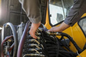 Un técnico repara un sistema con aceite hidráulico en un vehículo industrial