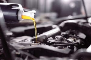 Un envase añade aceite de motor que se mezcla con el que ya tenía el vehículo