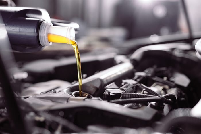 Un envase añade aceite de motor que se mezcla con el que ya tenía el vehículo